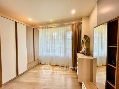 Spacious bedroom with large windows and elegant wooden flooring