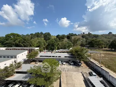 Scenic view of residential parking area surrounded by lush greenery and clear blue sky.