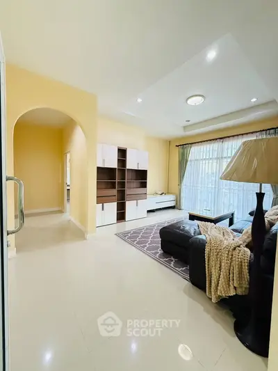 Spacious living room with modern decor and large window for natural light.