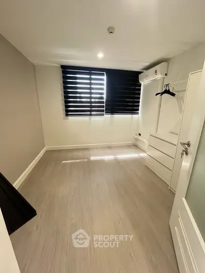 Modern minimalist bedroom with sleek flooring and air conditioning