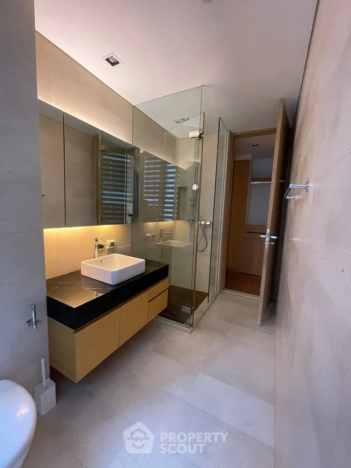 Modern bathroom with glass shower and sleek vanity in luxury apartment