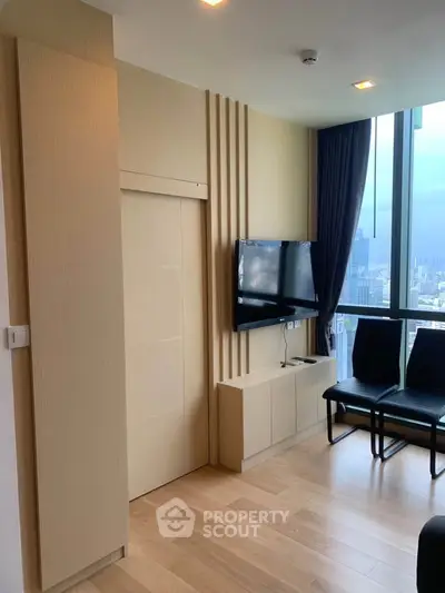 Modern living room with city view, featuring sleek TV setup and stylish decor.