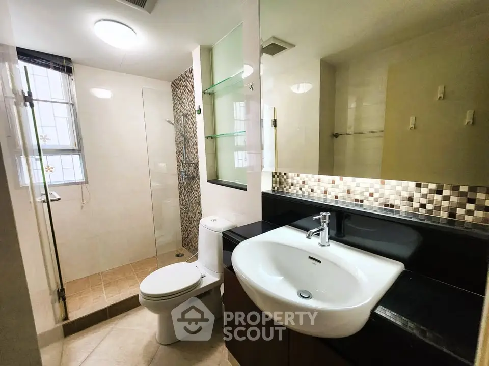 Modern bathroom with sleek fixtures and glass shower enclosure