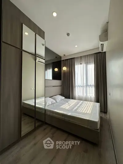 Modern bedroom with large mirrored wardrobe and natural light