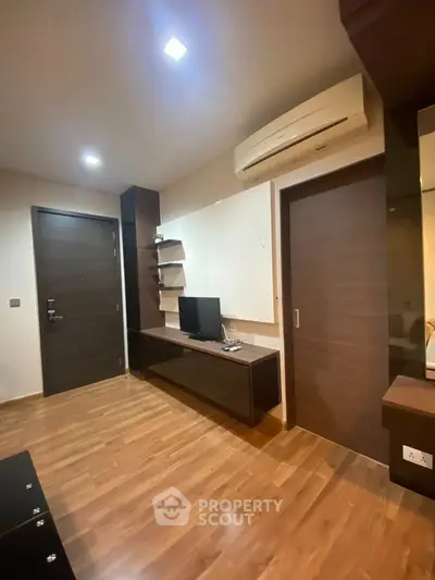Modern living room with sleek wooden flooring and built-in TV unit
