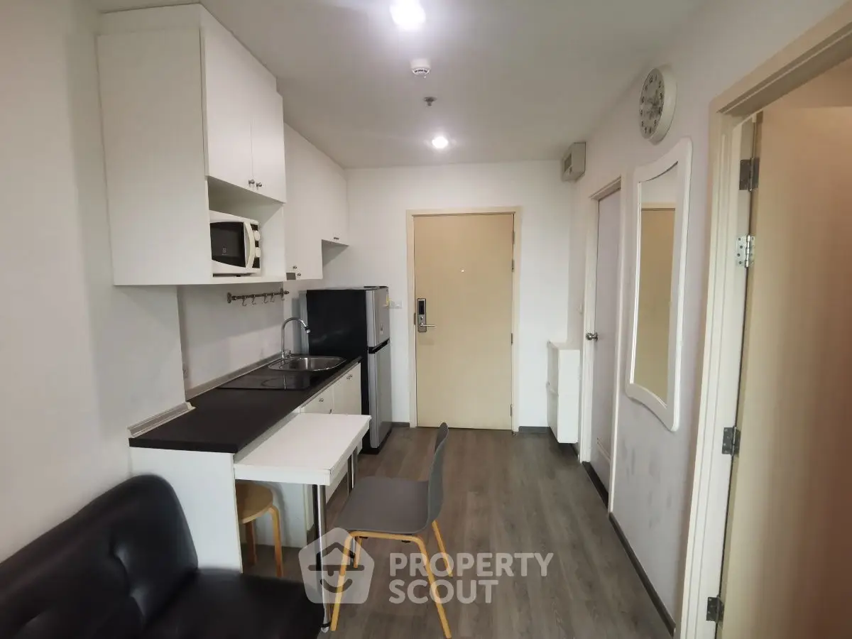 Compact modern kitchen with sleek cabinetry and integrated appliances in cozy apartment.