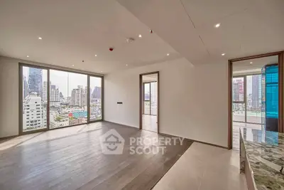 Spacious modern living room with city view and large windows in luxury apartment.