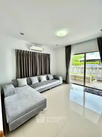 Spacious living room with modern gray sofa and large window view