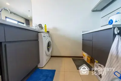 Modern kitchen with washing machine and sleek cabinetry