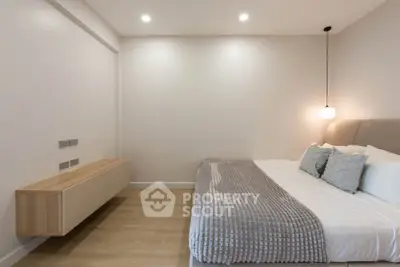 Modern minimalist bedroom with cozy bed and stylish lighting