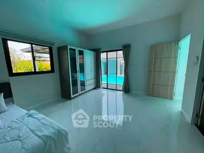 Spacious bedroom with pool view and modern wardrobe in a luxurious home