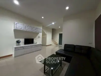 Spacious modern living room with sleek black sofa and stylish decor