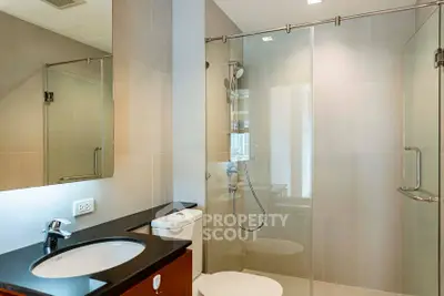 Modern bathroom with glass shower enclosure and sleek fixtures