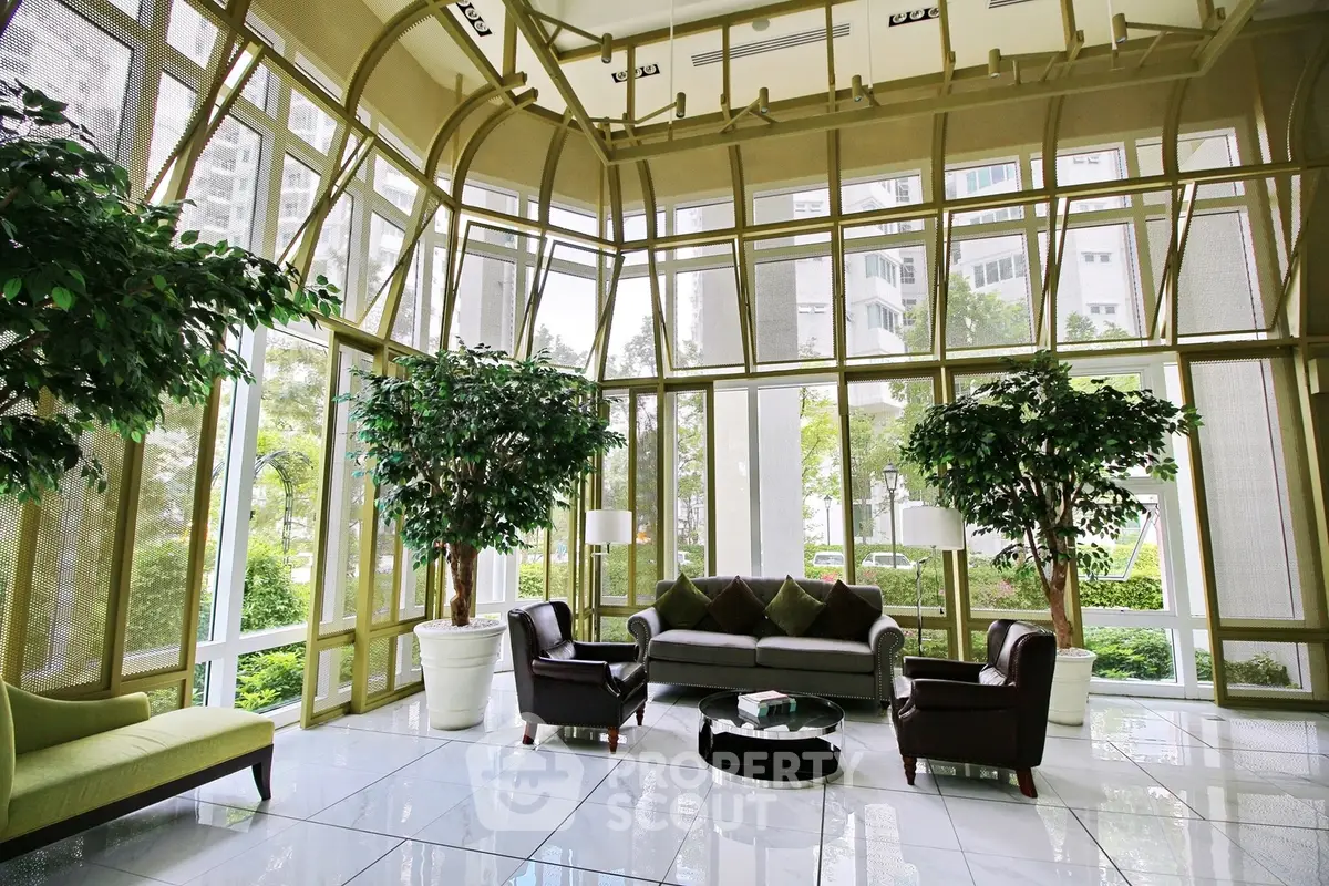 Luxurious living room with floor-to-ceiling windows and lush greenery views.