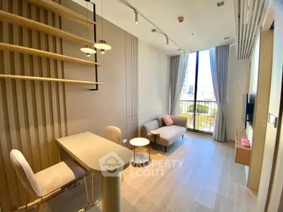 Modern living room with stylish decor and city view, featuring elegant furniture and natural light.