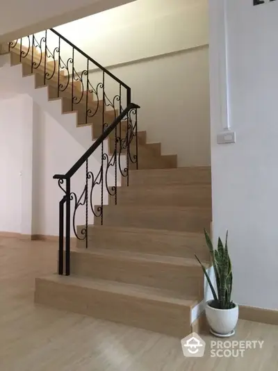 Elegant wooden staircase with decorative railing in modern home interior