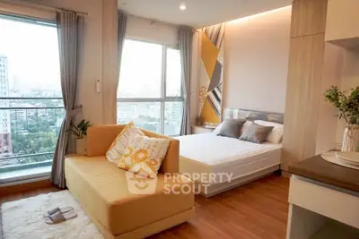 Modern bedroom with city view, featuring cozy seating and stylish decor.