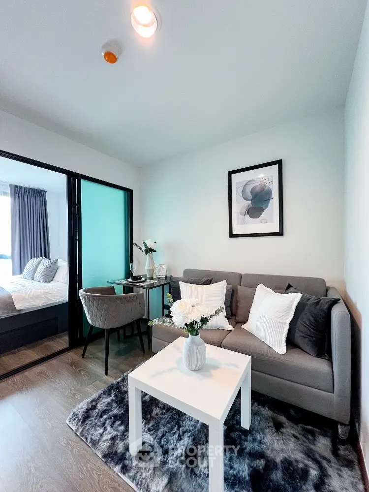 Modern living room with cozy decor and stylish furniture in a compact apartment setting.