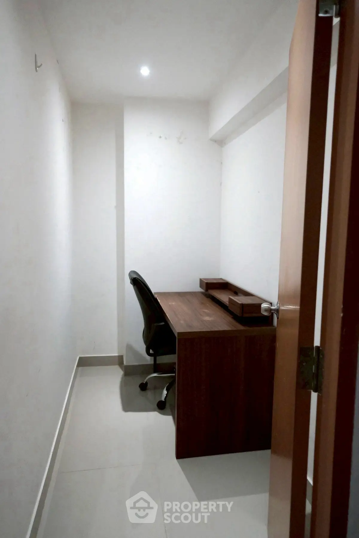 Compact study room with modern desk and chair, ideal for focused work in a cozy space.