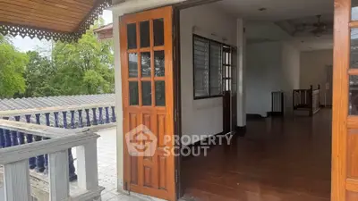 Spacious balcony with wooden doors and scenic view, perfect for relaxation and outdoor enjoyment.