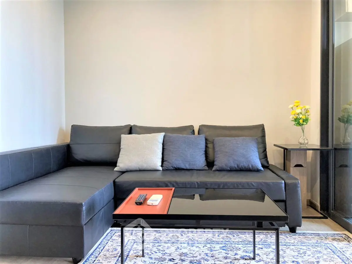 Modern living room with sleek black sectional sofa and stylish coffee table, perfect for contemporary living.