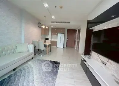 Spacious modern living room with elegant decor and open layout, featuring a cozy sofa and large TV unit.