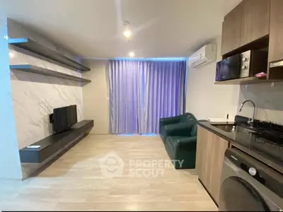 Modern living room with sleek kitchen, featuring TV, shelves, and washing machine in open layout.