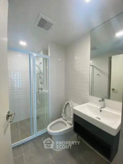Modern bathroom with glass shower and sleek fixtures in a contemporary apartment.
