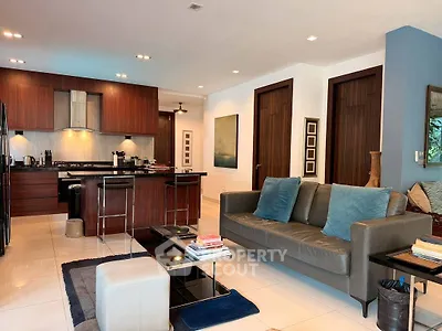Spacious modern living room with open kitchen, sleek furniture, and elegant decor in a luxurious apartment.