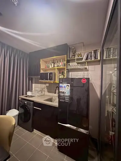 Modern compact kitchen with sleek black appliances and stylish shelving in a cozy apartment.