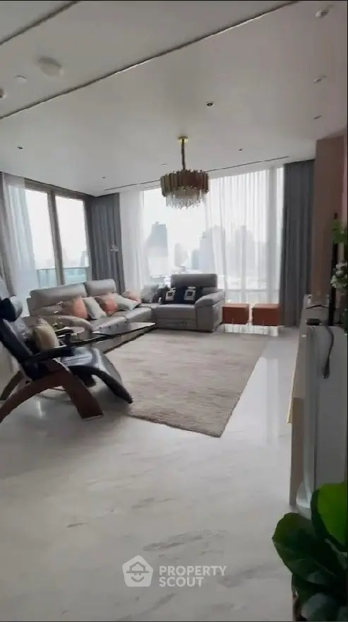 Luxurious high-rise living room with elegant chandelier, plush seating, and floor-to-ceiling windows offering a panoramic city view.