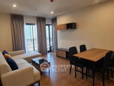 Modern living room with stylish furniture and balcony view in a high-rise apartment.