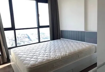 Spacious bedroom with large window offering stunning city views and ample natural light.