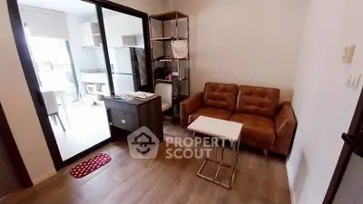 Cozy living room with brown leather sofa and modern decor in a compact apartment.