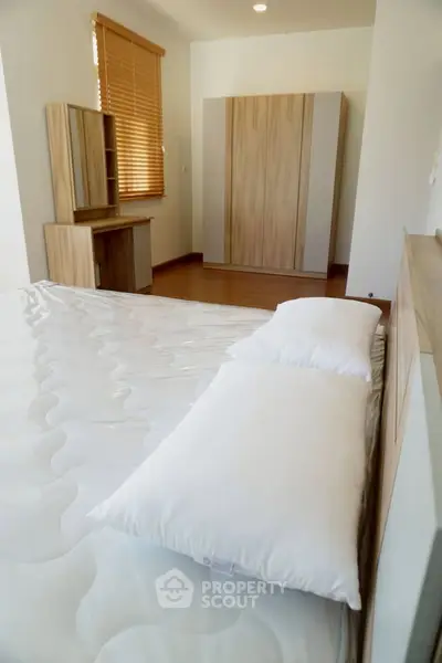 Spacious bedroom with modern wooden furniture and natural light