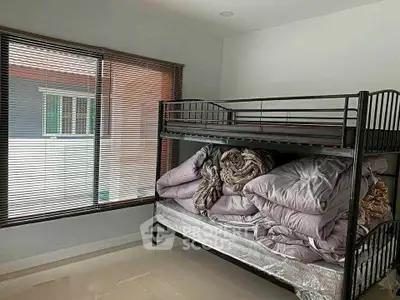 Cozy bedroom with bunk bed and ample natural light from large window.