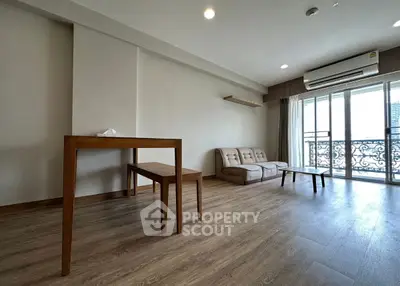 Spacious living room with modern decor and balcony view in a stylish apartment.