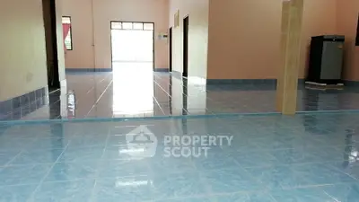 Spacious interior with glossy blue tiled flooring and open layout.