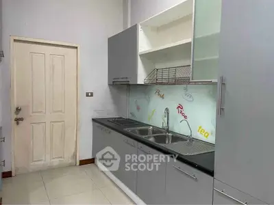Modern kitchen with sleek cabinetry and dual sinks in a compact layout.