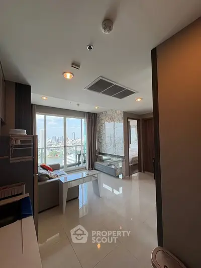Spacious modern living room with city view, featuring sleek furniture and large windows for natural light.
