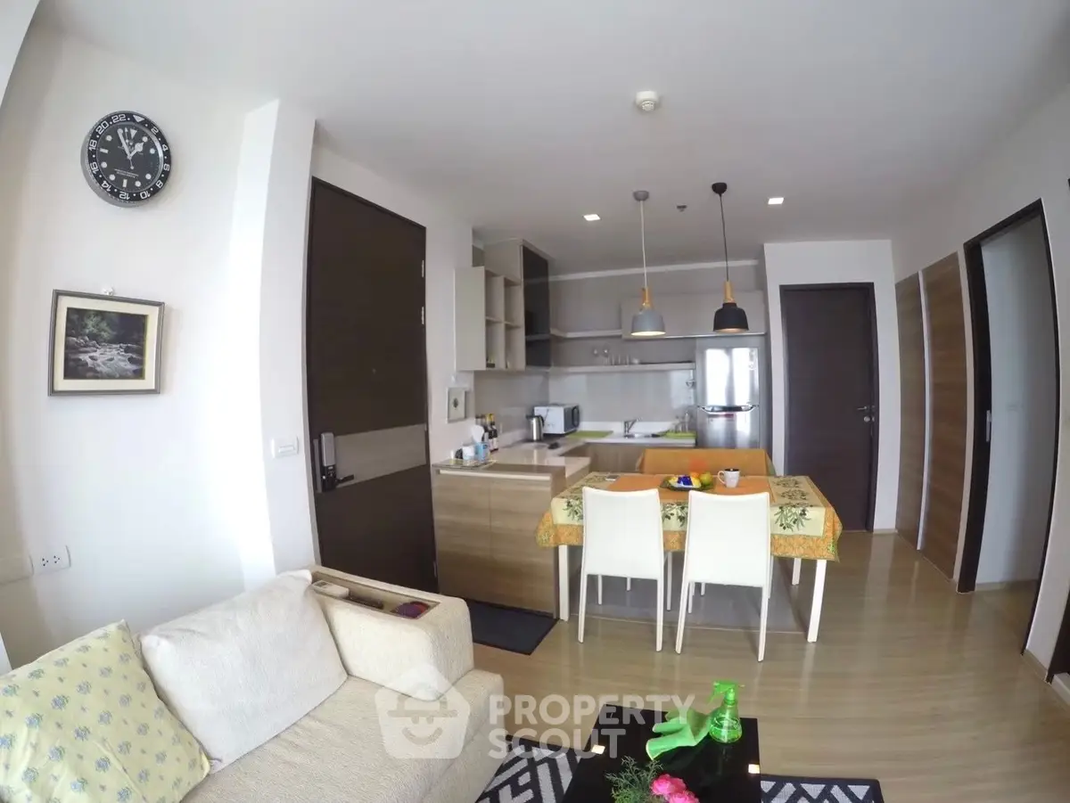 Modern open-layout living room with kitchen, stylish decor, and cozy seating area.