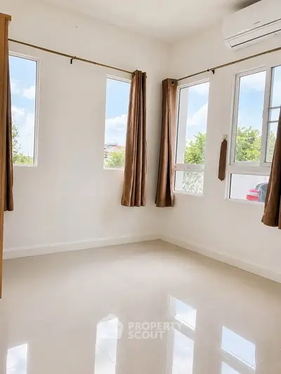 Bright empty room with large windows and air conditioning, perfect for customization.