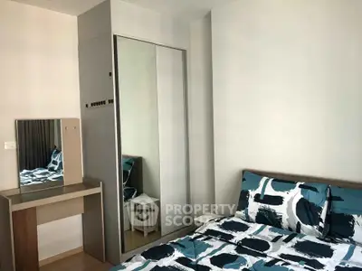 Modern bedroom with stylish bedding and mirrored wardrobe in a cozy apartment.