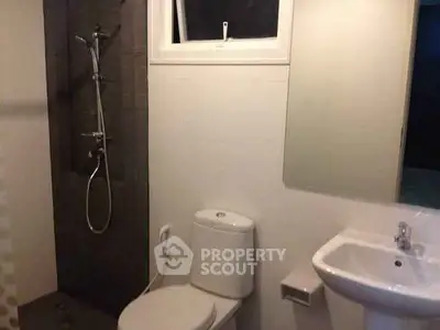 Modern bathroom with shower, toilet, and sink in a sleek design.