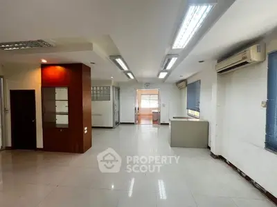 Spacious open-plan living area with modern lighting and air conditioning units.