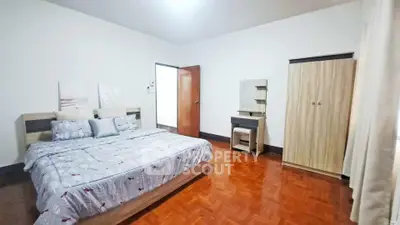 Spacious bedroom with modern furniture and wooden flooring