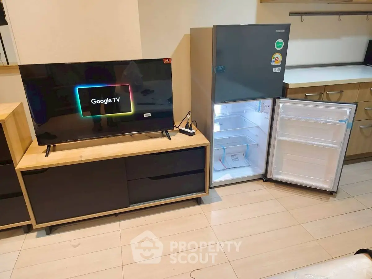 Modern living room with Google TV and sleek refrigerator in stylish interior.
