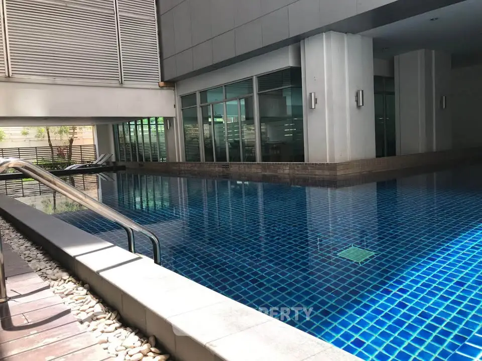 Luxurious indoor swimming pool in modern residential building with sleek design and ambient lighting.