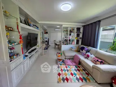 Spacious living room with modern decor and large windows in a cozy home setting.