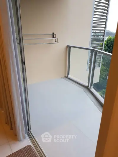 Spacious balcony with modern railing and serene view, perfect for relaxation.